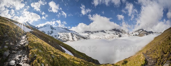 Hiking trail in front of snow-covered mountain peaks