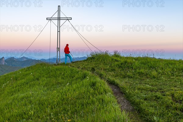 Small mountain trail with mountaineer and summit of the Uentschenspitze at sunrise