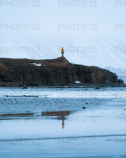 Person on a rock with reflection in water