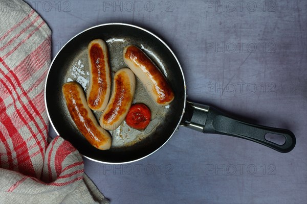 Chipolata sausages in pan