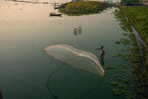 Fishermen on Taung Tha Man Lake throw out a fishing net for sunrise