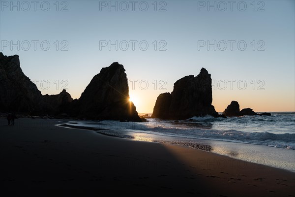 Marked rocks at Praia da Ursa beach at sunset