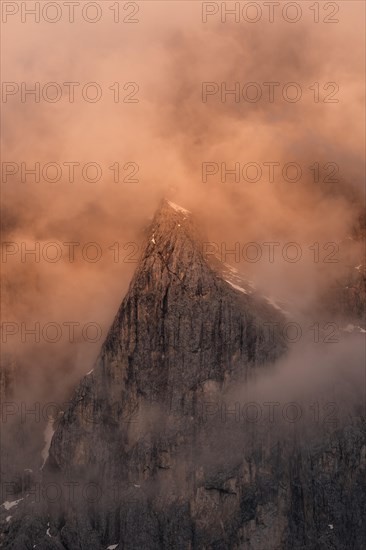 Rock face framed by clouds at sunset