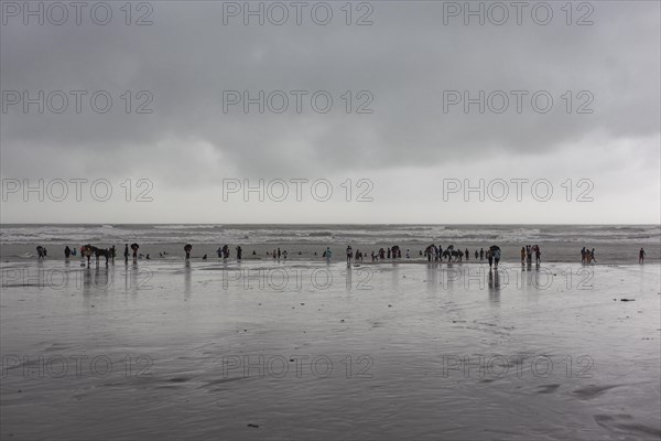 Bathers on the beach from Cox's Bazaar to monsoon rain