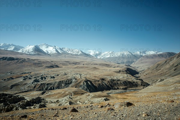 Barren plateau with rock formations and the canyon of the Wachandarja River