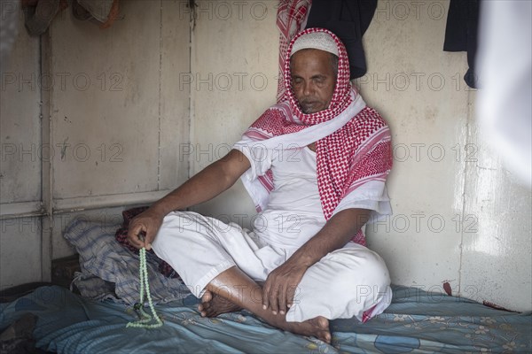 Sailor praying in his sleeping cabin on a freighter in the port of Mongla