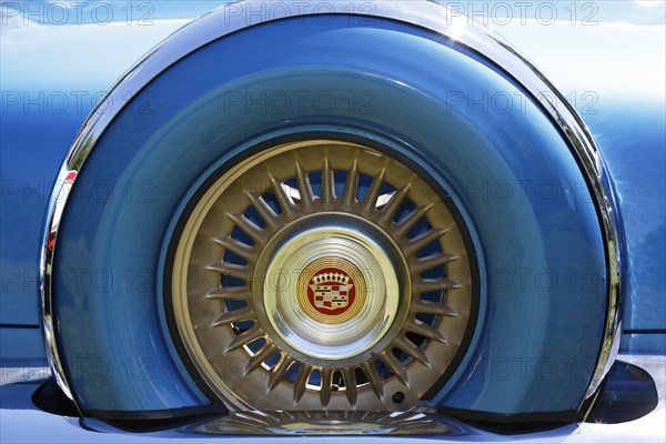 Cadillac emblem in the rim of the spare tyre at the rear of a 1956 Cadillac Eldorado classic car