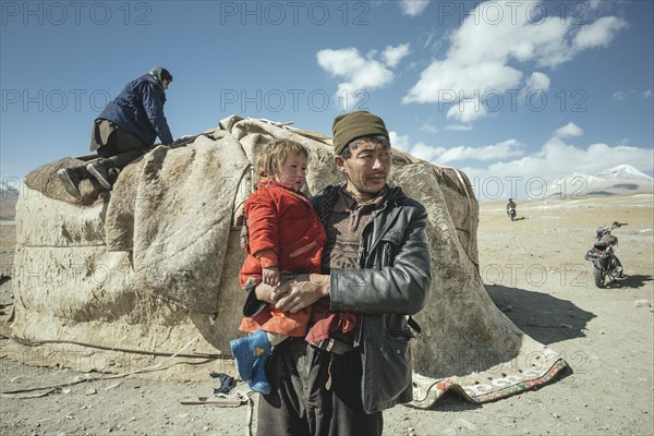 Man carrying child in his arms