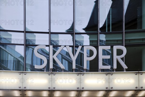 Skyper lettering in front of glass facade