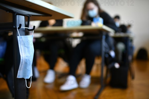 Face mask hangs on school desk