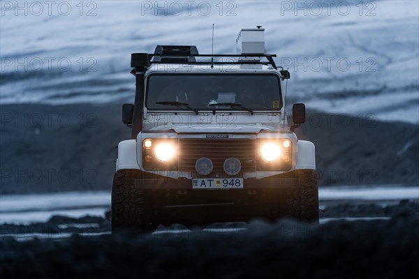 White Land Rover Jeep in front of a glacier