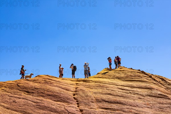 Tourists on the top of an ochre cliff