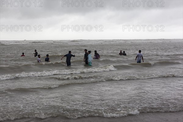 Bathers on the beach from Cox's Bazaar to monsoon rain