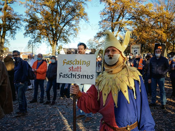 A man dressed as a joker with a Hitler beard