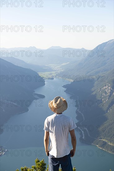 Young man looks over mountain landscape