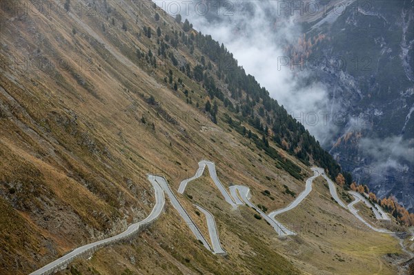 Pass road in autumn with wafts of mist