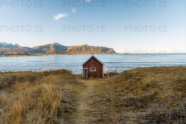 Red cabin in front of Ramberg beach at sunset