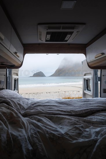 View from the rear of the campervan to beach with turquoise water
