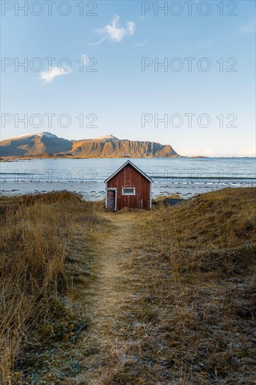 Red cabin in front of Ramberg beach at sunset