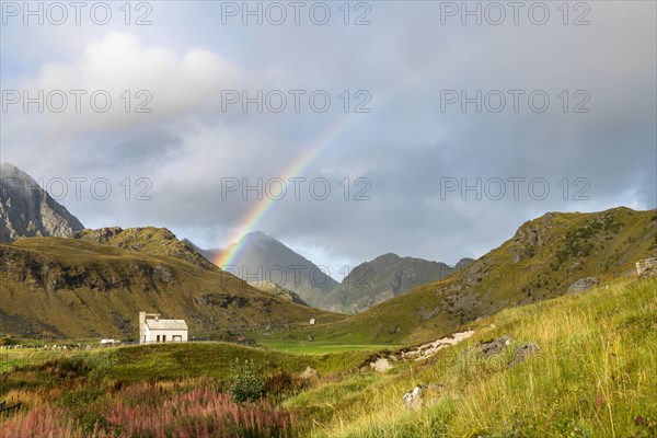 Chapel with rainbow in the mountains of Lofoten