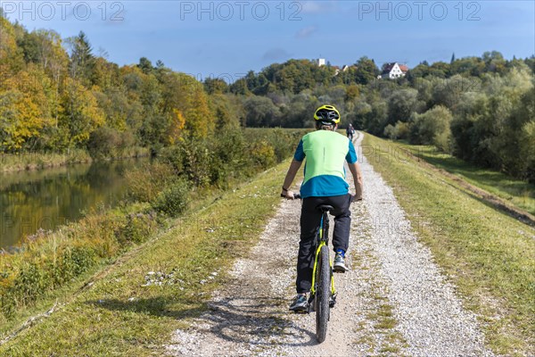 Cycle cyclist on cycle path on the canal dam of the Isar
