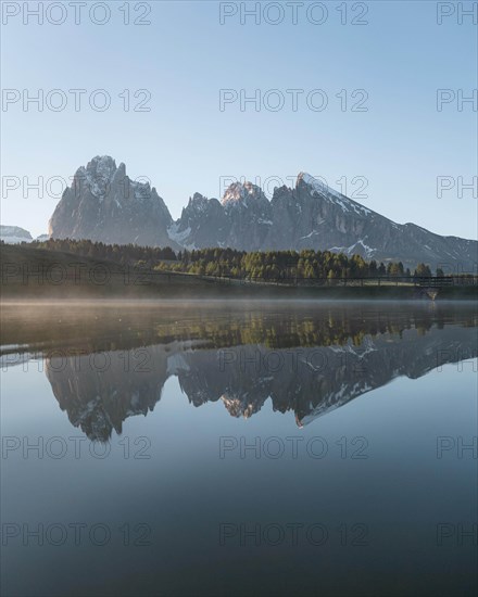 Sassolungo and Plattkofel are reflected in the small lake