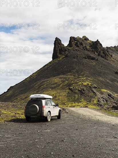 All-terrain vehicle with roof tent next to gravel road on Stapafell mountain