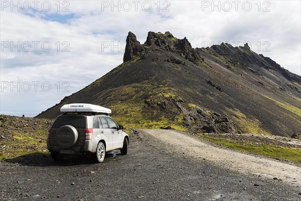All-terrain vehicle with roof tent next to gravel road on Stapafell mountain