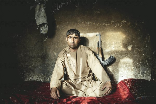 Man sitting on a mattress on the floor in a house