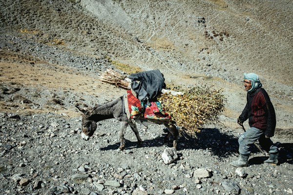 Man walking through barren mountain landscape