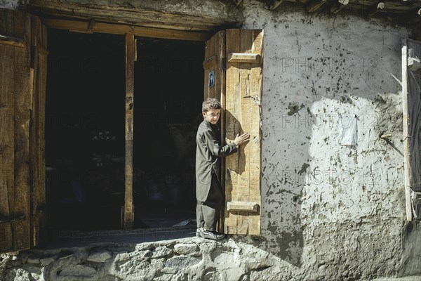 Boy looks out an open double door