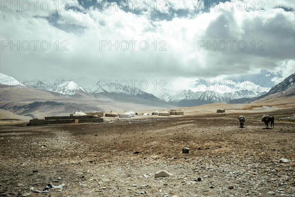 Stables made of stone and yurts of a Kyrgyz nomad camp