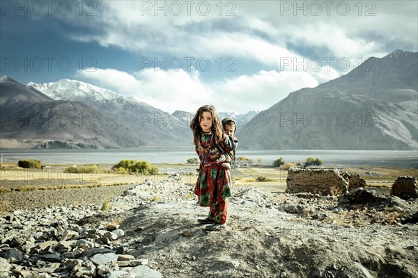 Girl carrying her little brother on her back