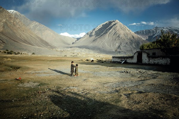 Two boys playing on the threshing floor during the wheat harvest