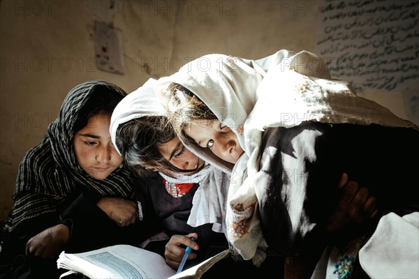 Three girls working with a textbook