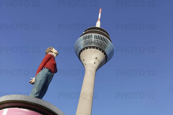 Realistic female figure on an advertising pillar in front of the Rhine Tower