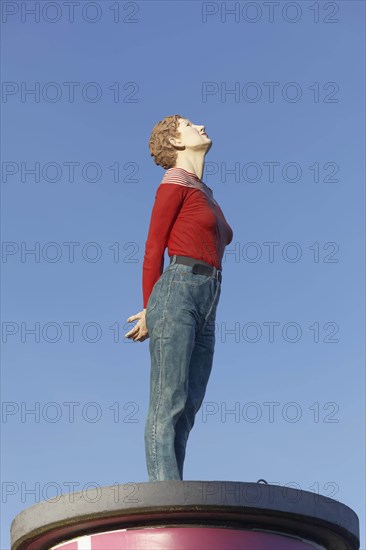 Realistic female figure on an advertising pillar