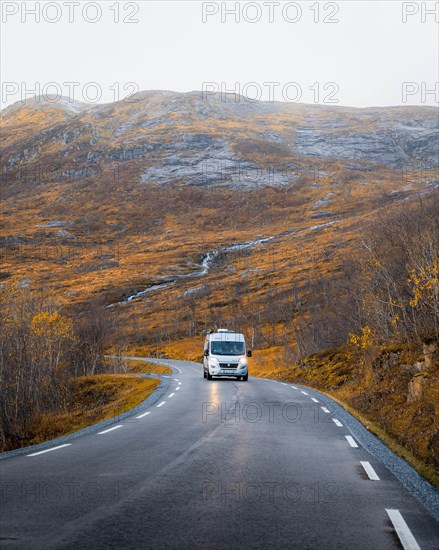 Campervan on a road with autumnal vegetation