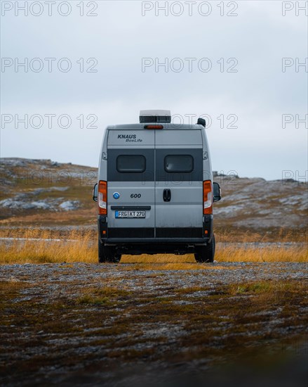 Campervan with rear view standing on parking lot near Kafjord