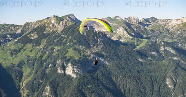 Paraglider in flight in front of the Rofan Mountains