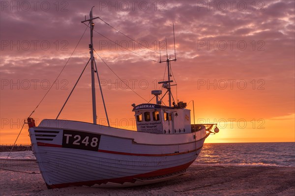 Fishing boat on the beach at sunset