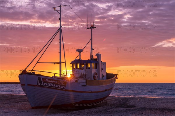 Fishing boat on the beach at sunset