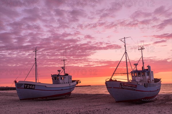 Fishing boats on the beach at sunset