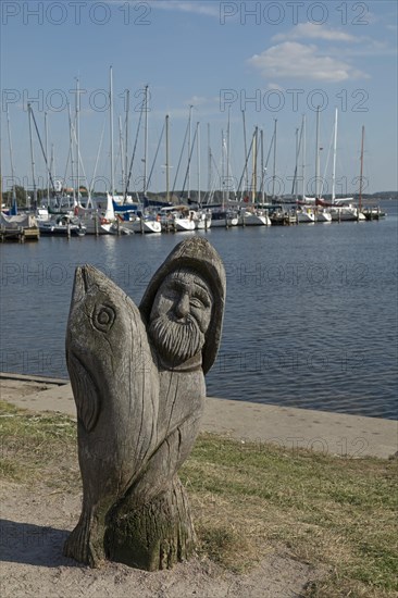 Wooden figure of a fisherman with fish at the marina