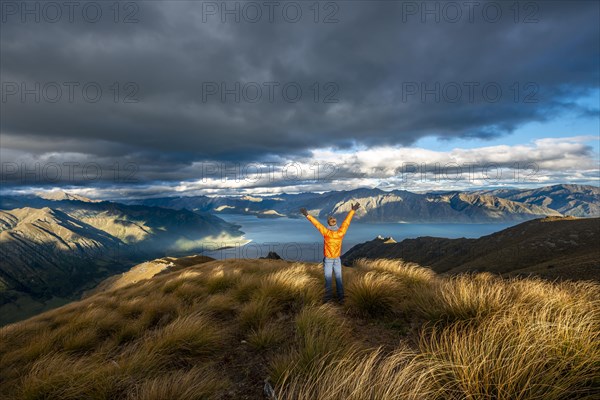 Hiker stretches his arms in the air