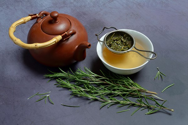 A cup of rosemary tea with tea strainer