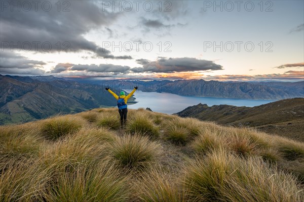Hiker stretches her arms in the air
