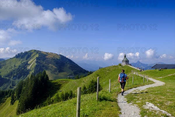 Hiker in front of the Wallberg church Heilig Kreuz