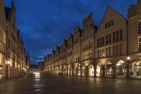 Illuminated historic gabled houses in the evening at blue hour