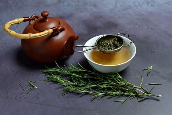 A cup of rosemary tea with tea strainer